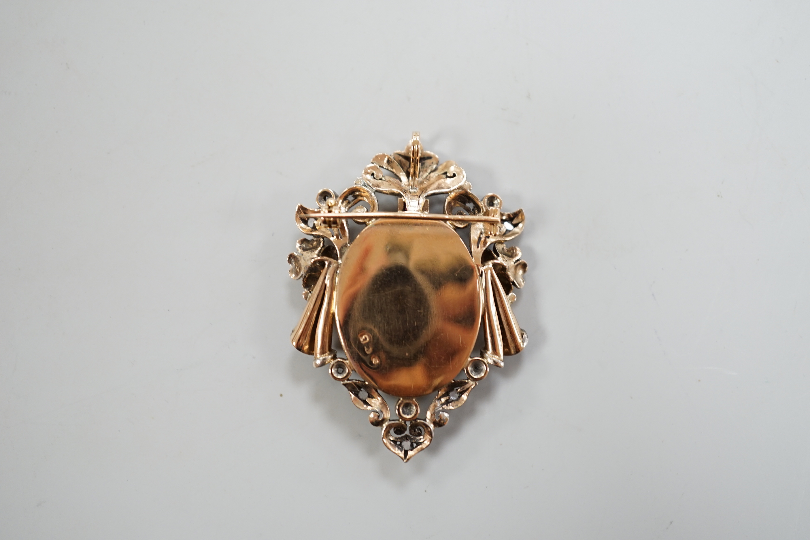 A late 19th/early 20th century continental yellow metal, seed pearl, ruby and diamond mounted pendant brooch, with inset oval miniature watercolour of a lady, indistinctly signed, 47mm, gross weight 10 grams., CITES Subm